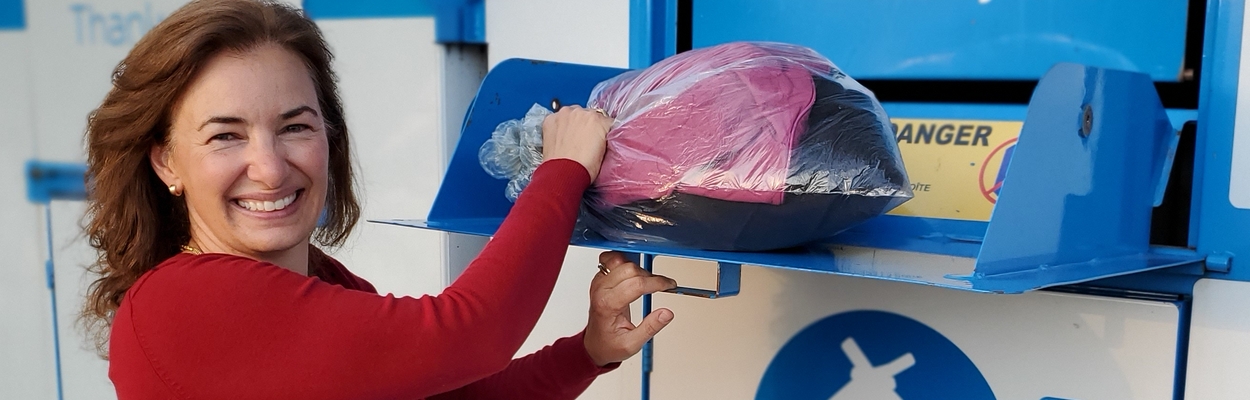 A resident opening the bin and donating a large bag of clothing.