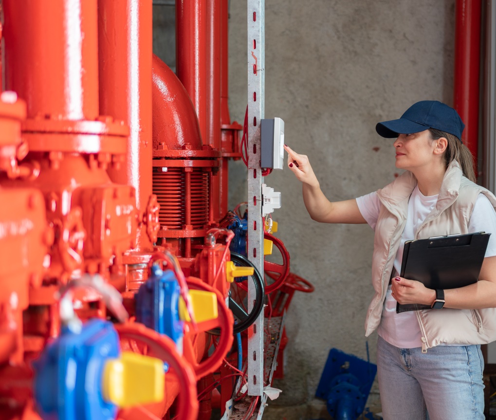 A maintenance worker checks heating pipes for a modern community energy system