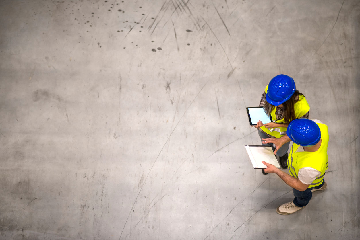 Overview of two workers in safety gear working in a warehouse.