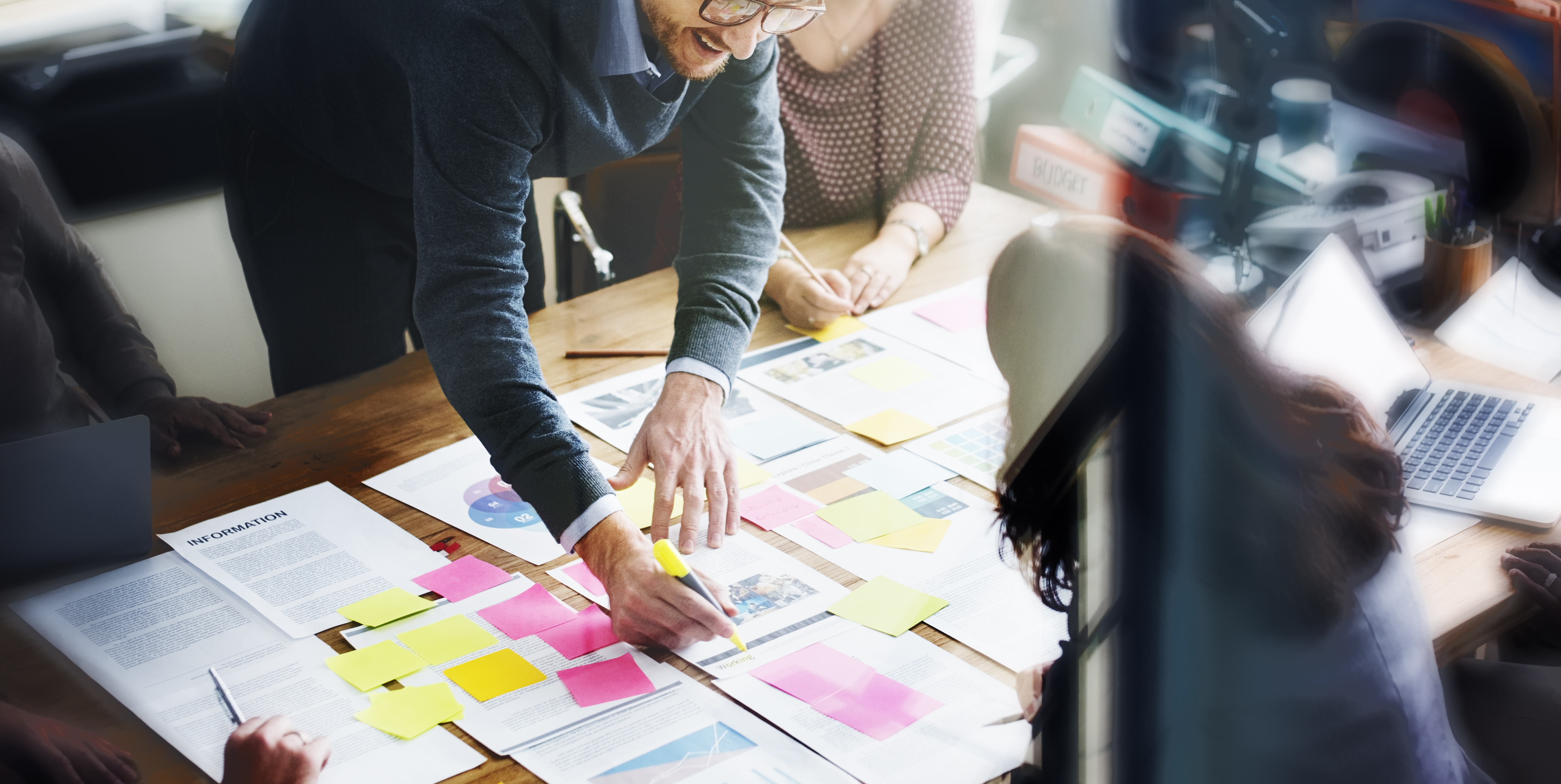 People working around a table developing plans.