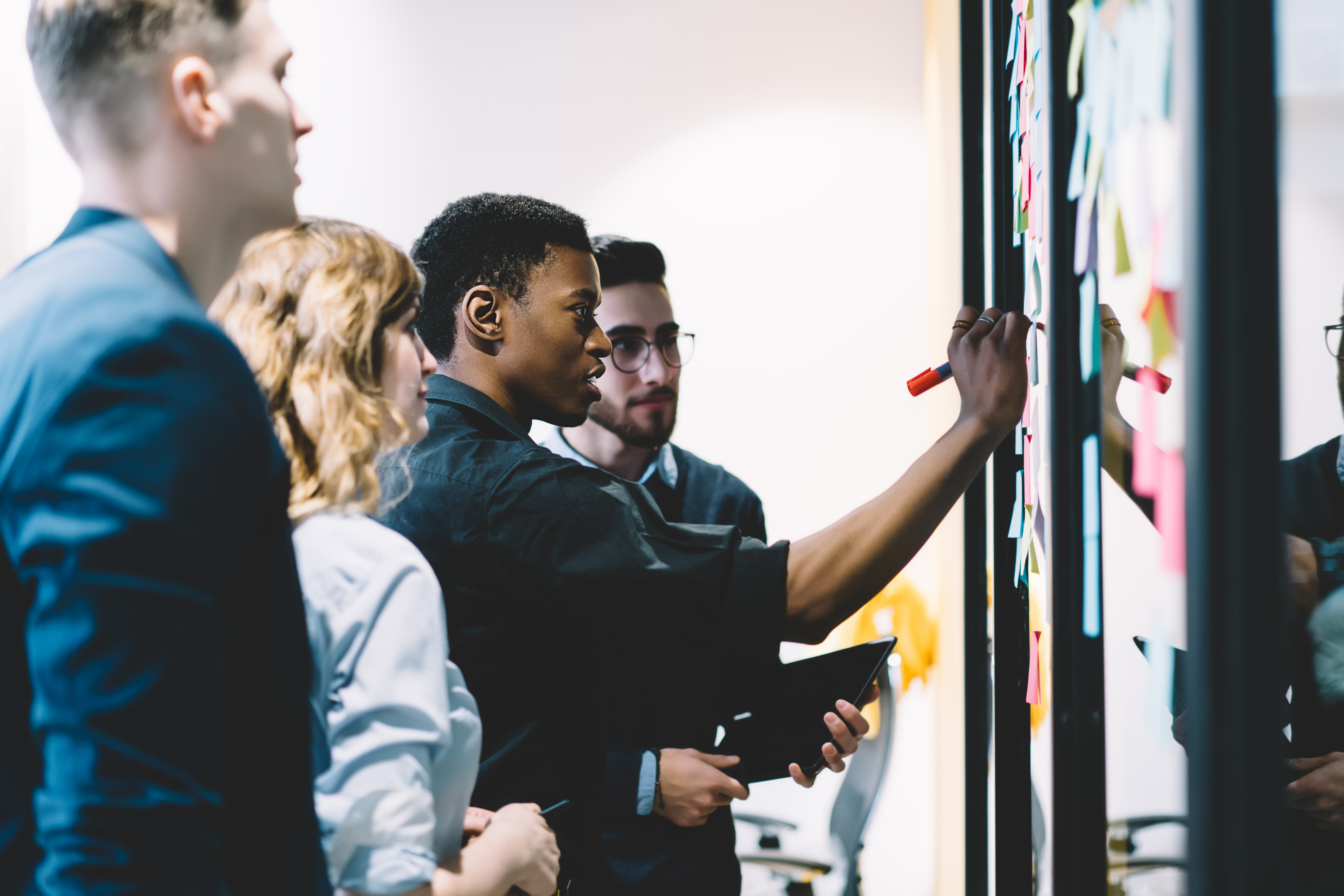 Image of people working together at a whiteboard.