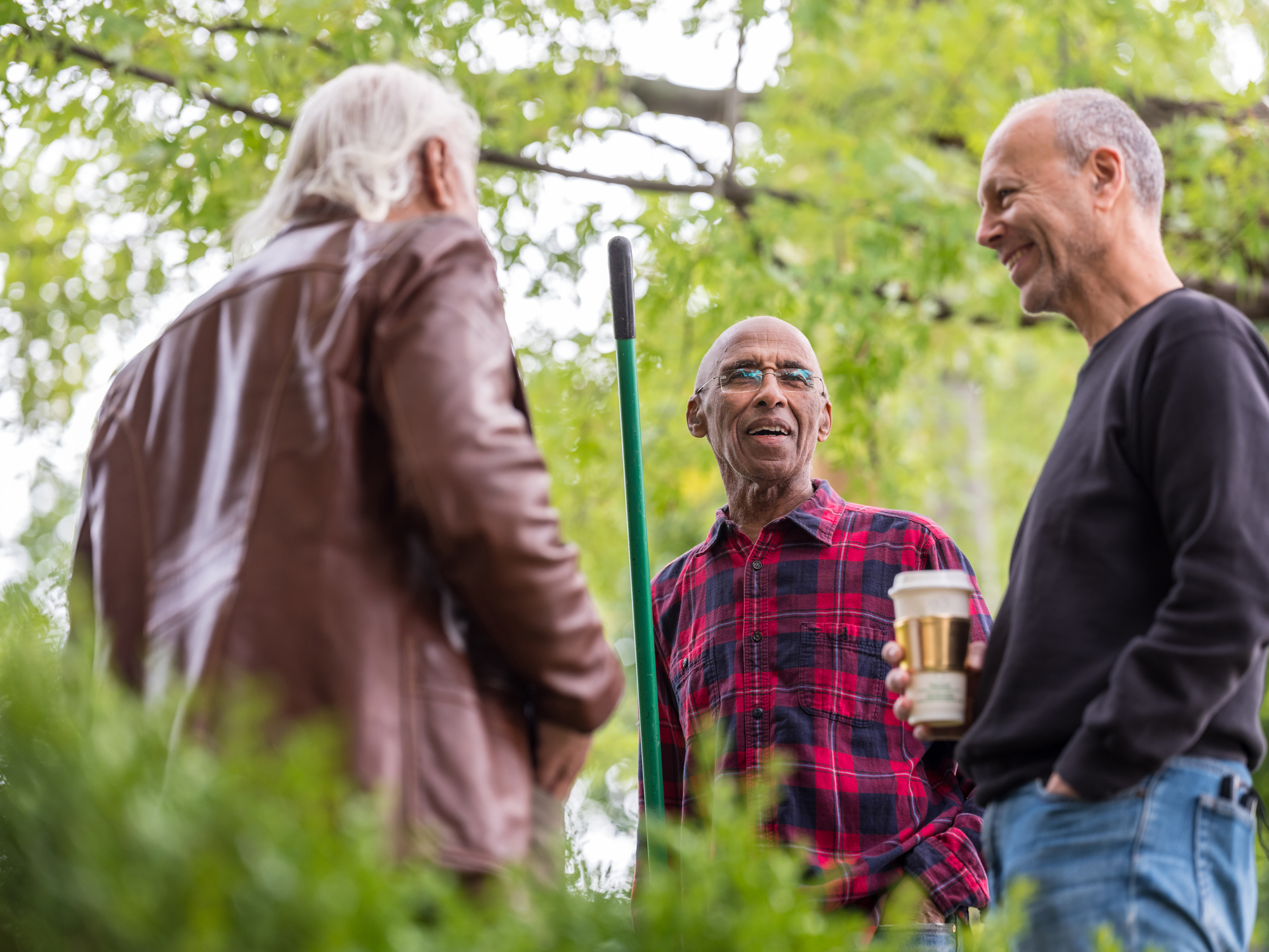 Three community members discuss their neighborhood’s urban forestry plan.