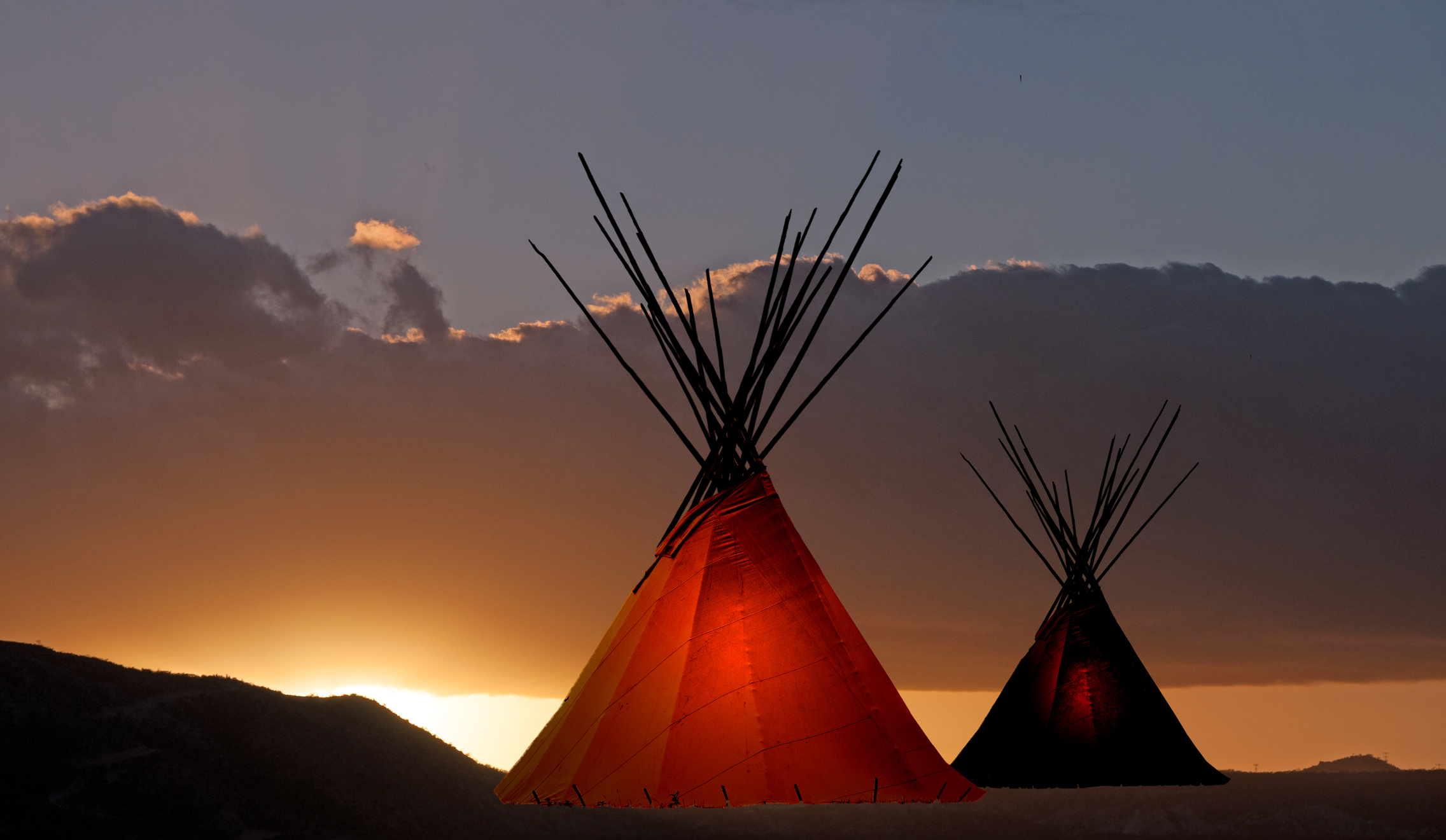 Two teepees at sunset. 