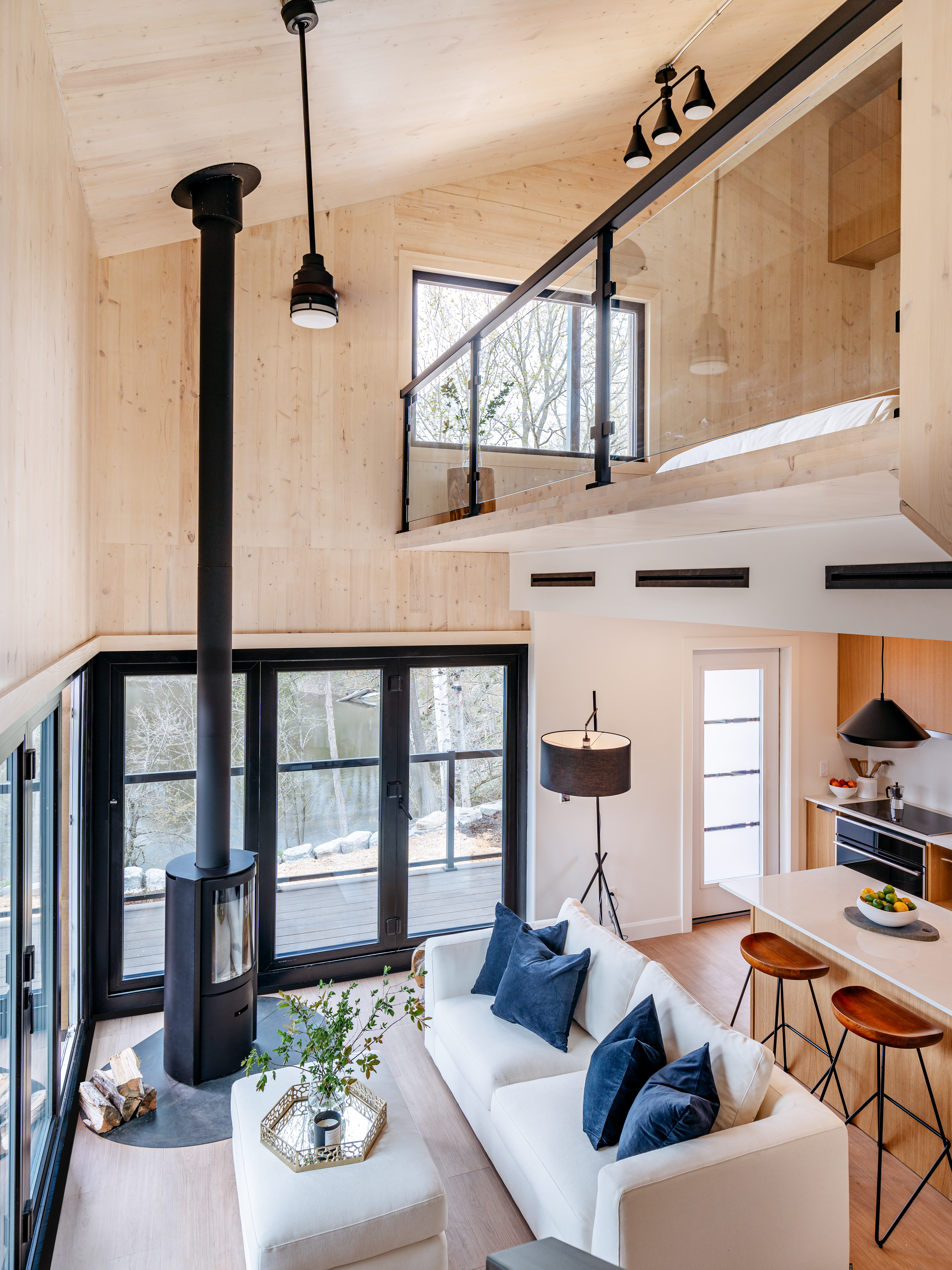 The interior of a CABN home with a kitchen, living room, fireplace, upper loft and new furnishings