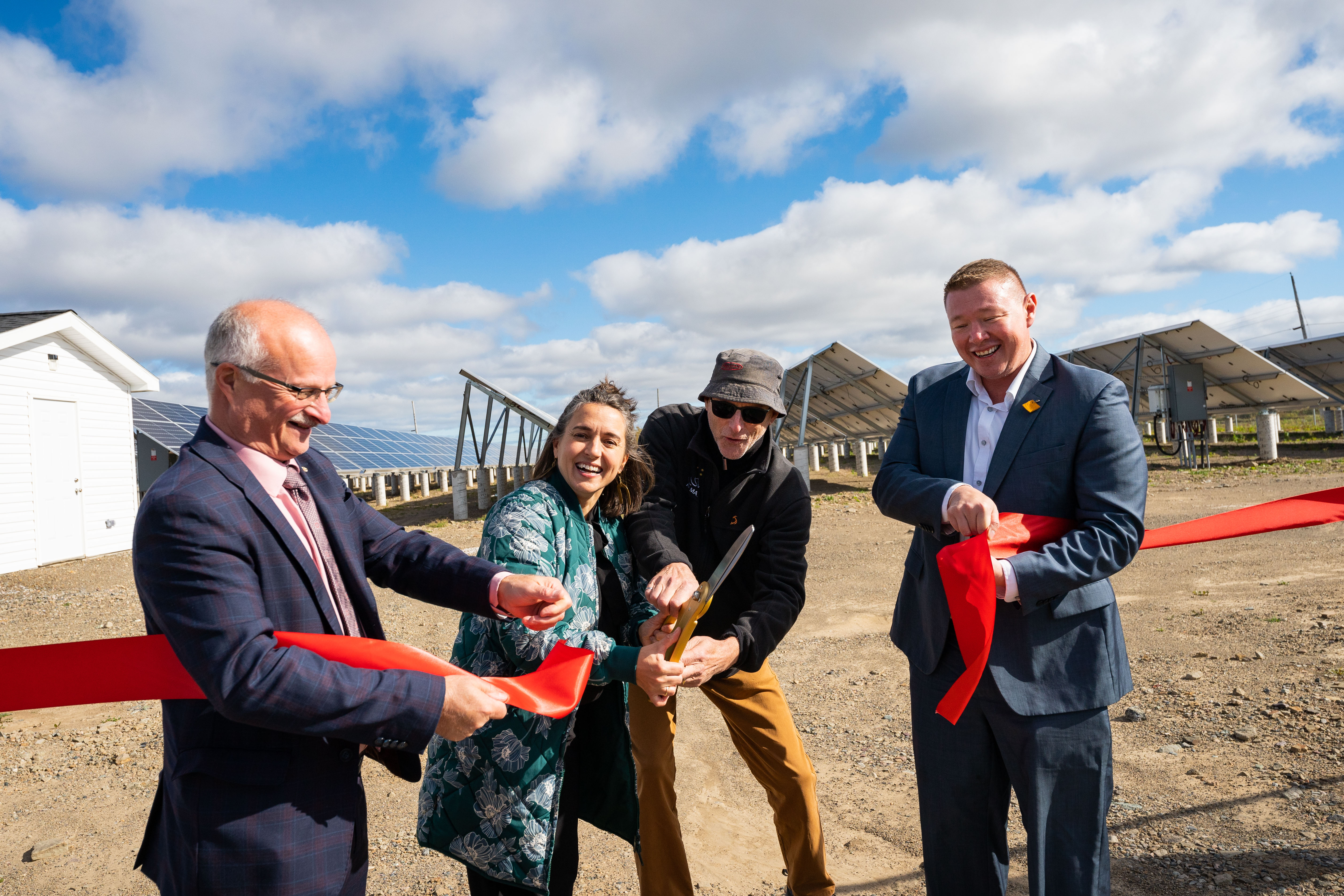 A group of people celebrates the ribbon-cutting of the Pine Tree Park project in Cape Breton, Nova Scotia