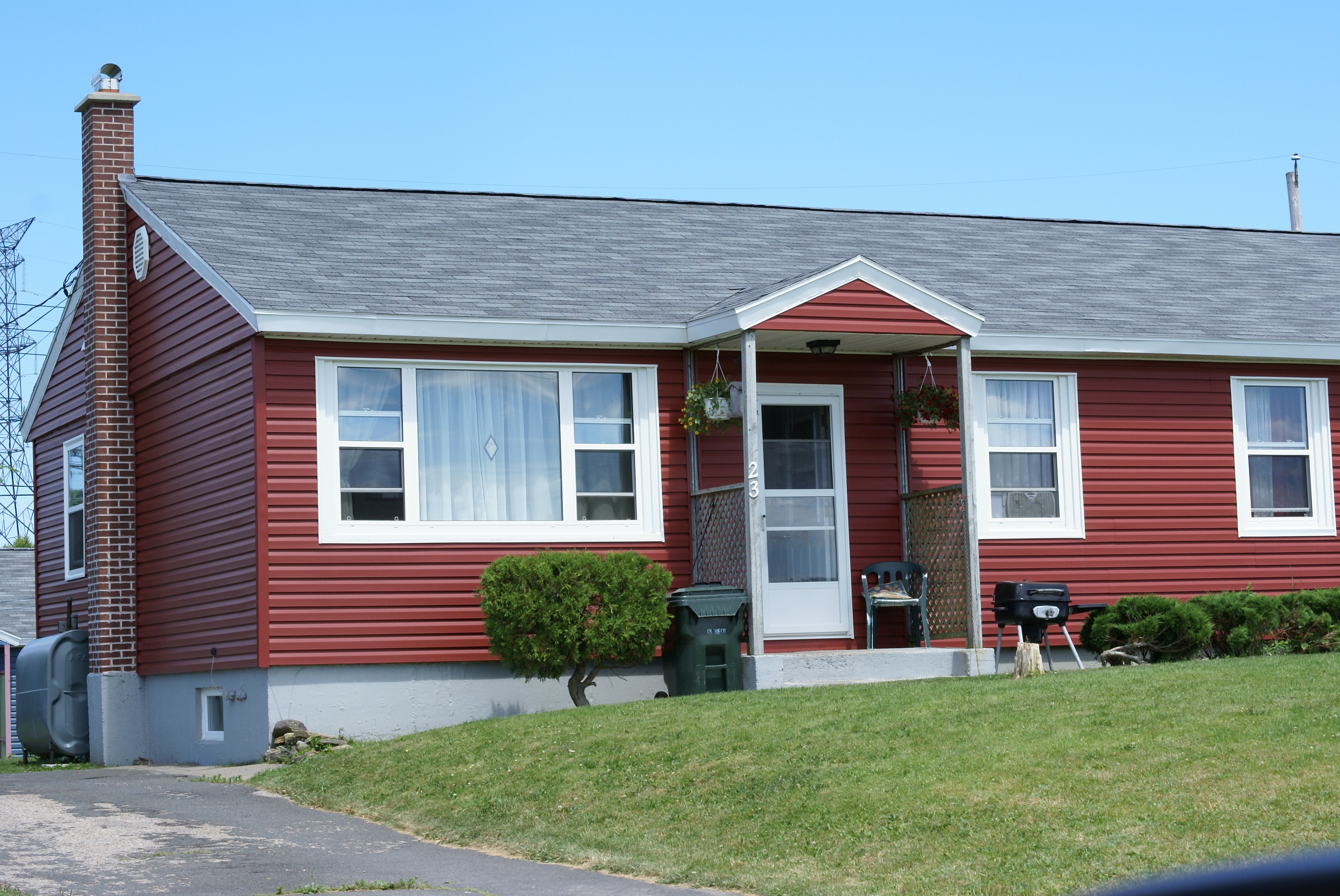 A single-storey home with red siding that is part of the Pine Tree Park project in Cape Breton, Nova Scotia