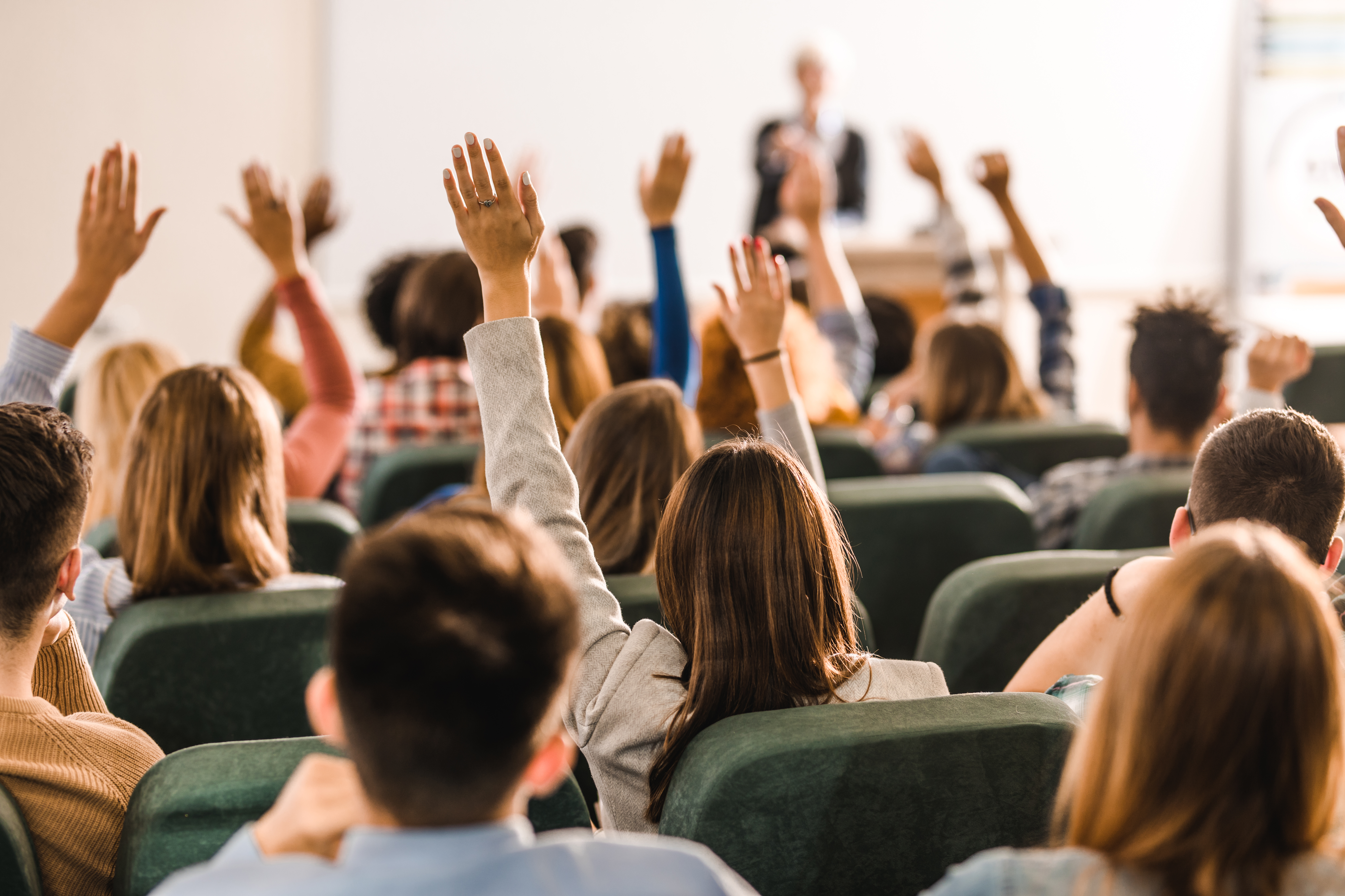 A diverse group of people raising their hands together, symbolizing inclusive participation and amplifying diverse voices in climate adaptation.