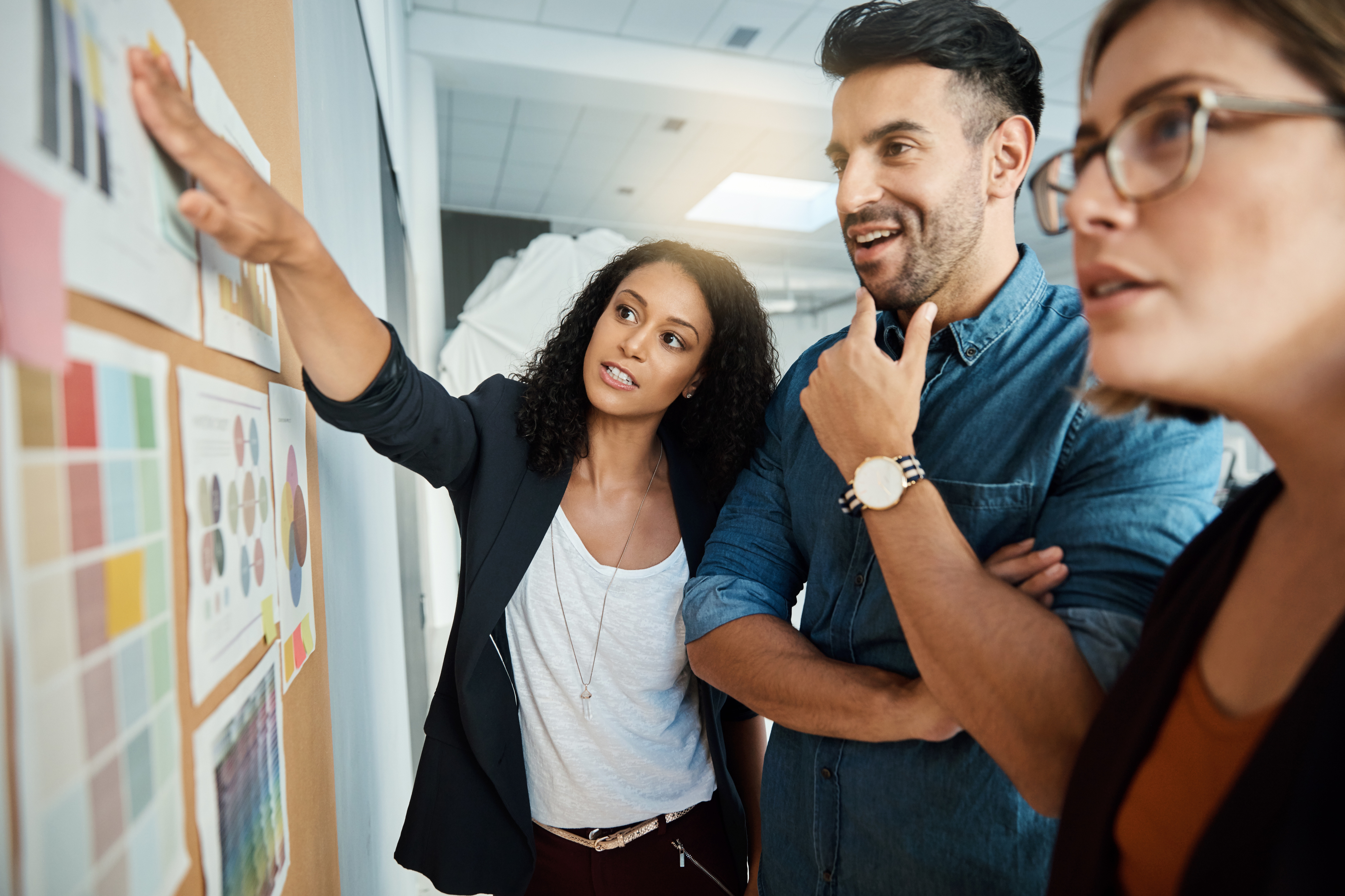 Three professionals collaborating in front of a board with charts, symbolizing municipal climate risk assessment. 