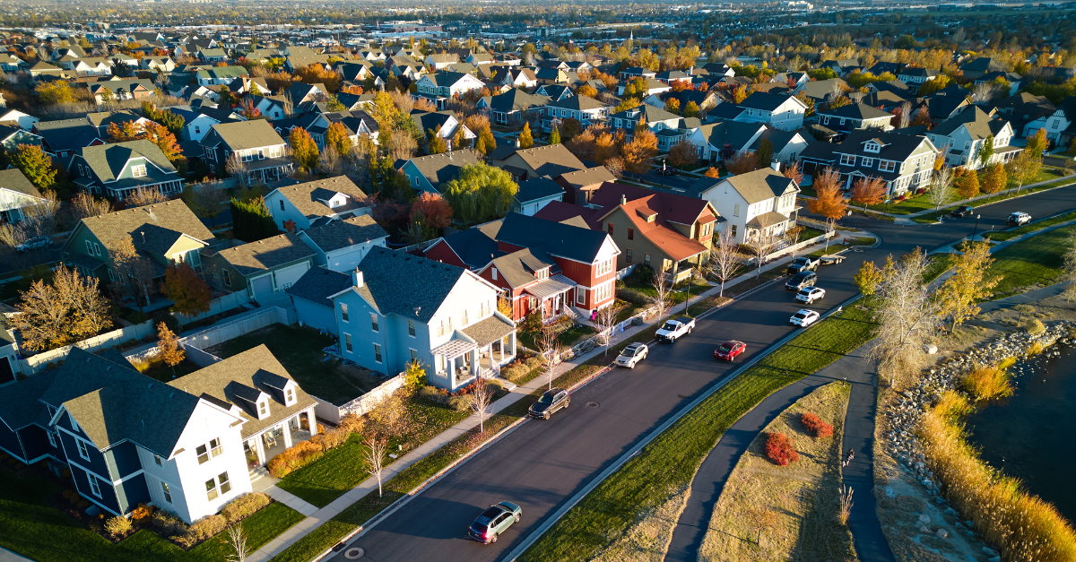 Aerial view of rows of houses and cars on the street.