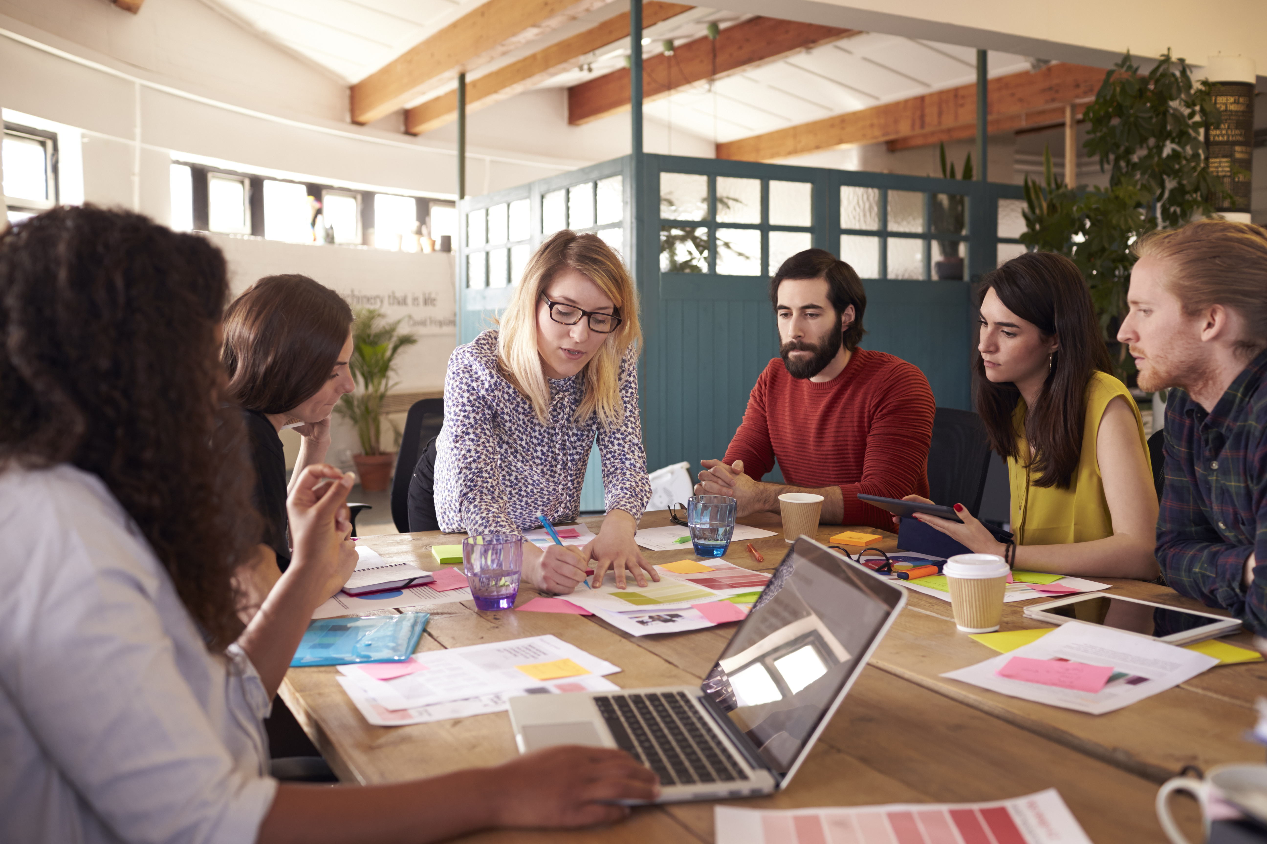 A group of colleagues reviewing documents together around a table. 