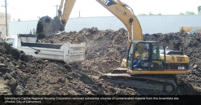 Excavator removing contaminated material from brownfield site, Edmonton, Alberta