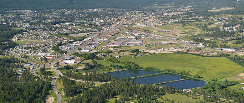 Aerial view of City of Cranbrook, BC. Image shows mountains in background, city and the wastewater treatment plant.