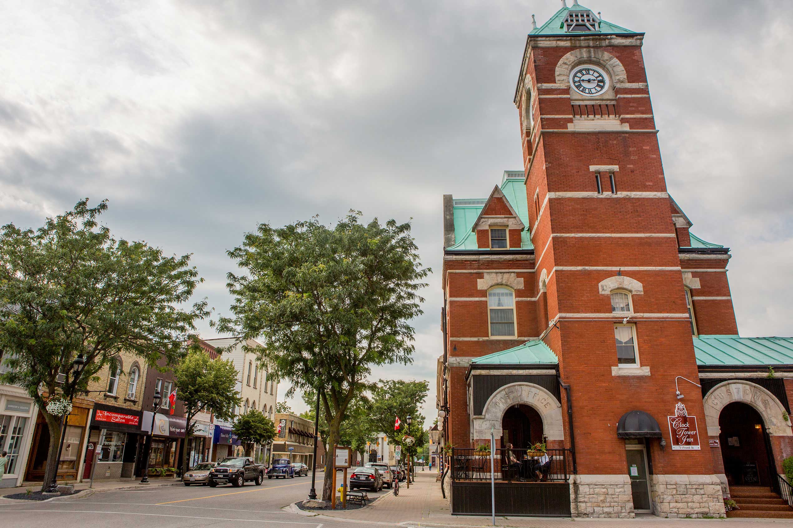 Photograph of tree-lined Frank Street, one of the main streets in Strathroy-Caradoc, with the red brick clock tower building in the foreground.