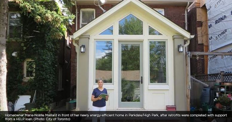 Woman who received a Home Energy Loan Program loan standing on the front lawn of her home Toronto, ON