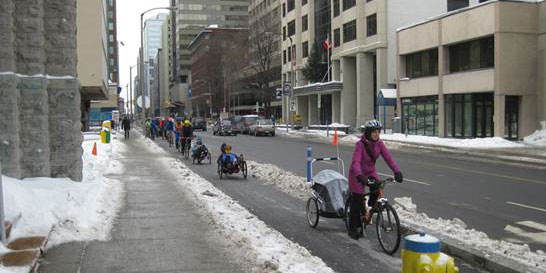Cyclists riding on Ottawa bike path in winter.