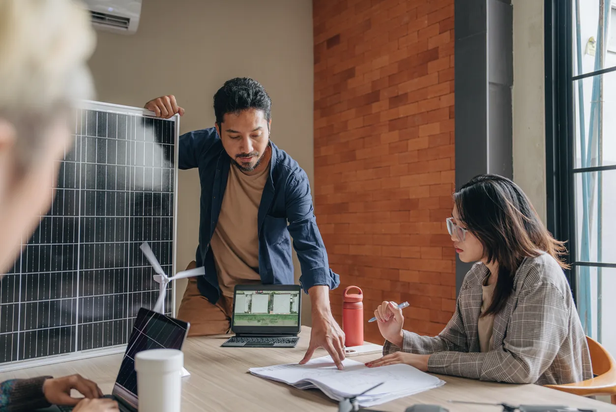 City planning meeting with the speaker holding a solar panel