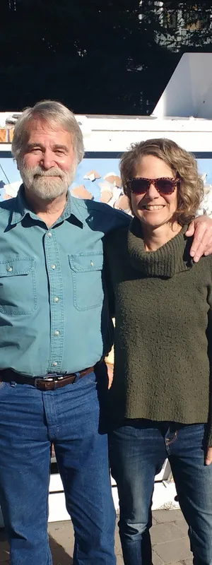 Canmore Mayor John Borrowman and artist Pascale Ouellet stand in front of a compost bin with local artwork.