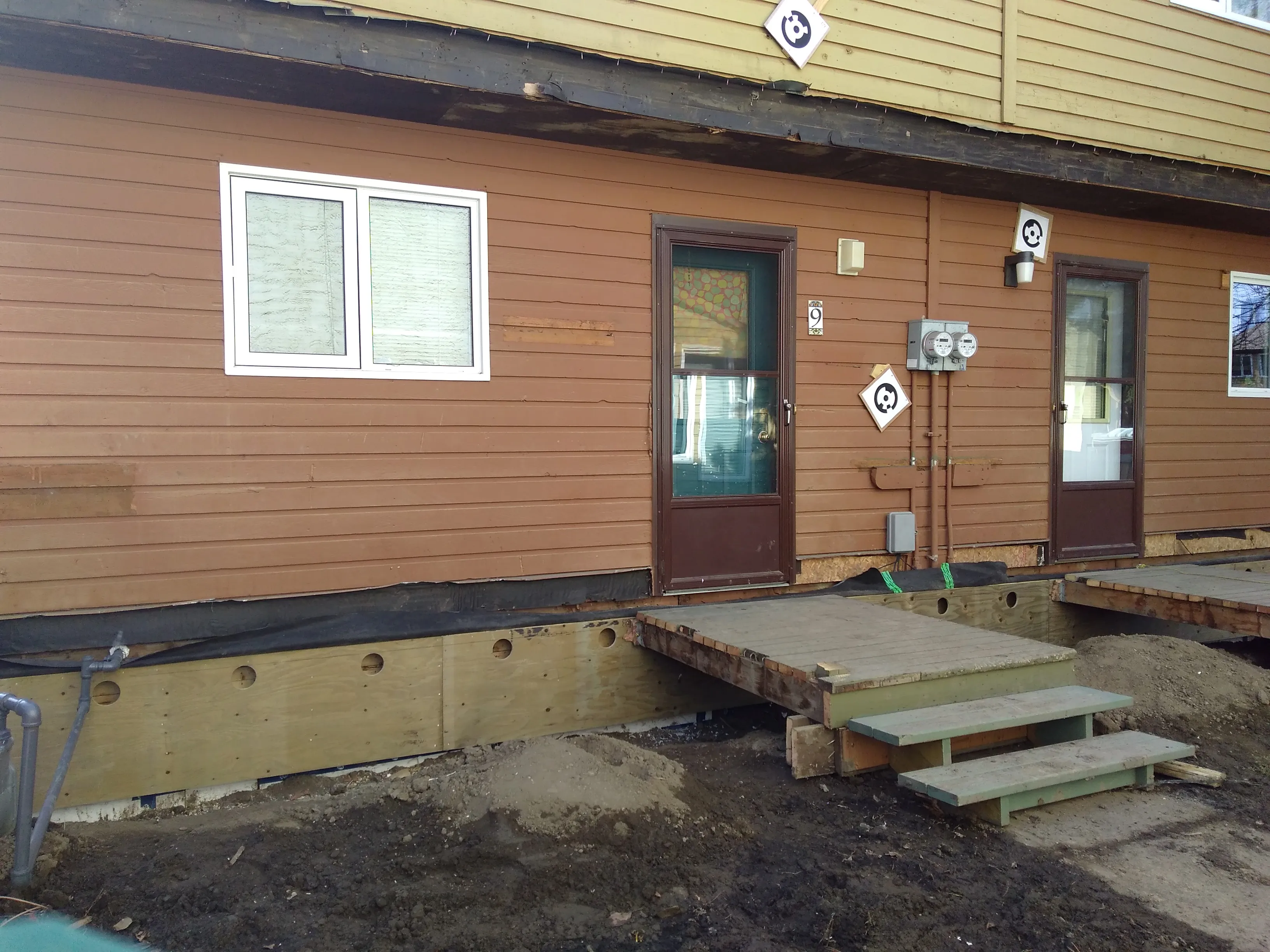 The lower floor of a home at Sundance Housing Co-operative is seen under renovation, with the top part of its foundation exposed above ground level.
