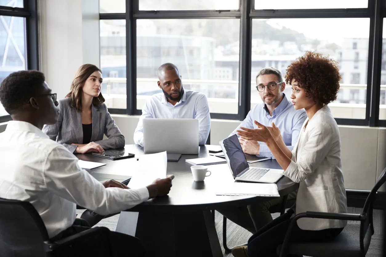 businesswoman addressing colleagues at a corporate business meeting