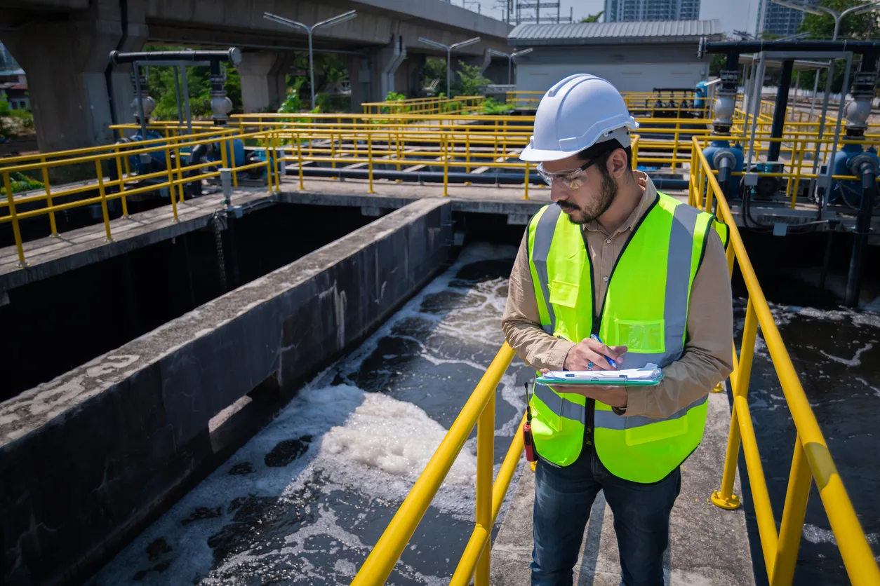 A municipal worker inspects a water treatment facility to support climate resilience. 
