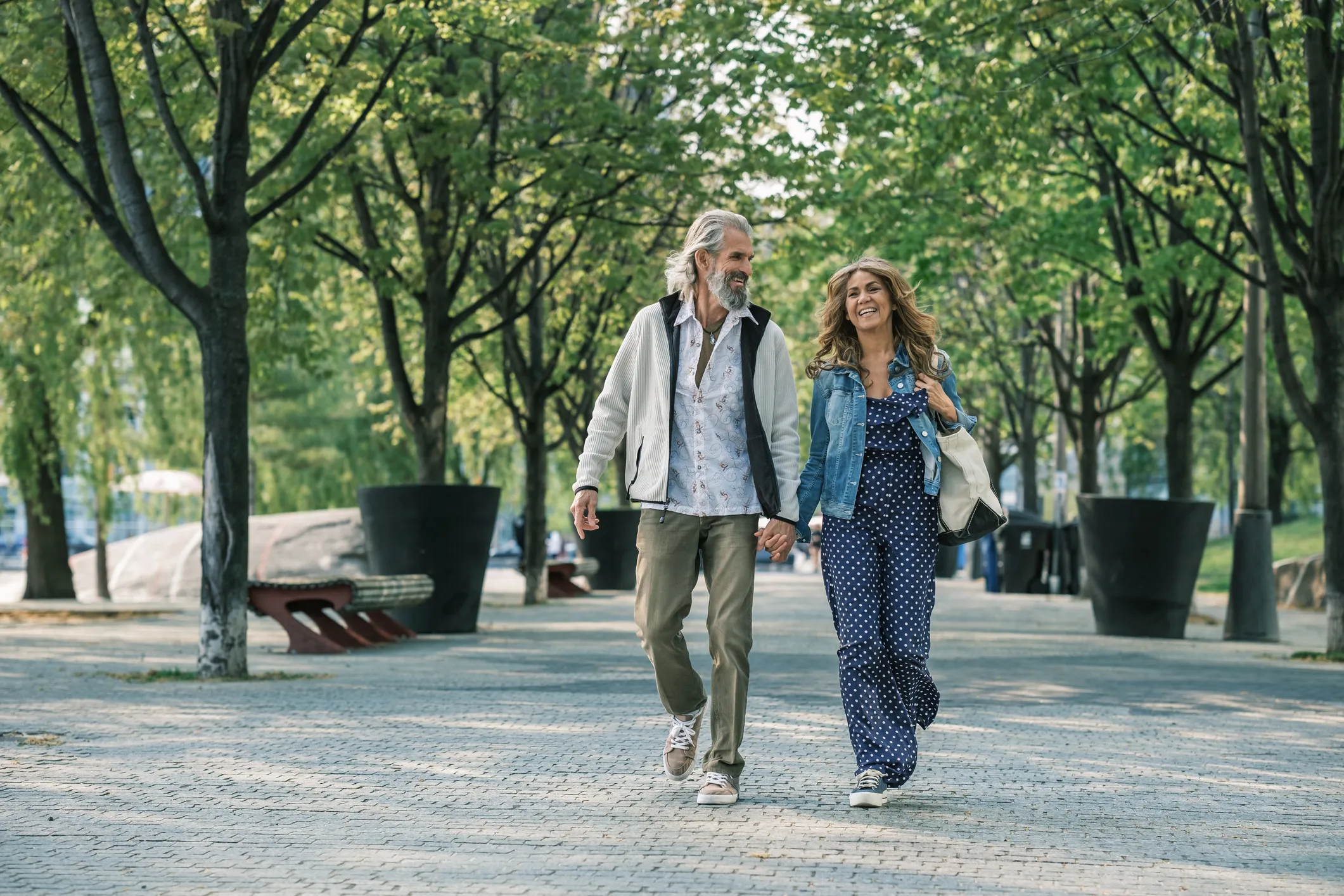 A couple walking under urban tree canopy
